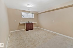 Window with blinds, built-in cabinet with sink and countertop, ceiling-mounted light fixture, light-colored walls, and mixed flooring - 
