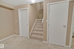 Plush carpet flooring, neutral wall tones, white trim, and staircase with carpeted treads - 