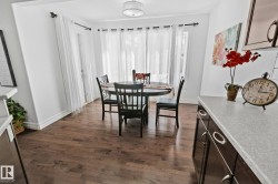 Wood-finish flooring, white walls, built-in cabinetry with silver hardware, light-toned countertop, and a ceiling-mounted light fixture - 