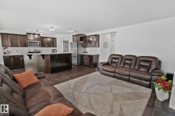 Open-concept living area featuring dark wood-finish flooring, white walls, and recessed lighting - 