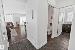 Dark-toned tile flooring, white interior walls, and contemporary white trim work - 
