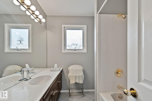 Bathroom featuring a vanity with an integrated sink, polished chrome faucet, and dark wood-finish cabinetry - 14724 73 Street Nw, Edmonton, AB 