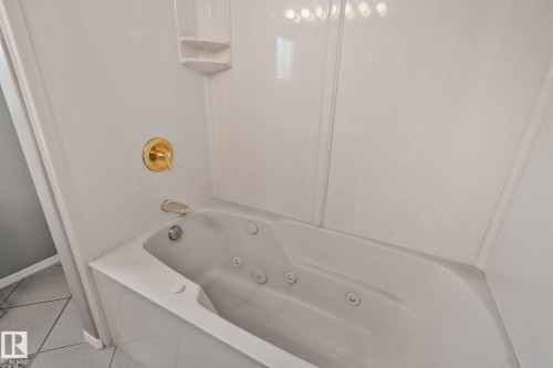 Jetted soaking tub with bright white surrounds and gold-finish fixtures - 14724 73 Street Nw, Edmonton, AB 