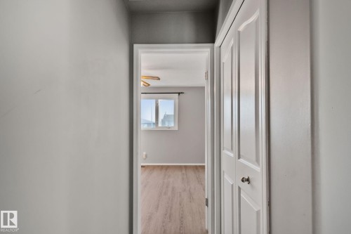 Neutral gray wall paint, doorway to a room with wood-finish flooring, white trim, and a window - 14724 73 Street Nw, Edmonton, AB 