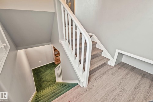 Two-tone staircase featuring light wood-finish treads and white balusters - 14724 73 Street Nw, Edmonton, AB 
