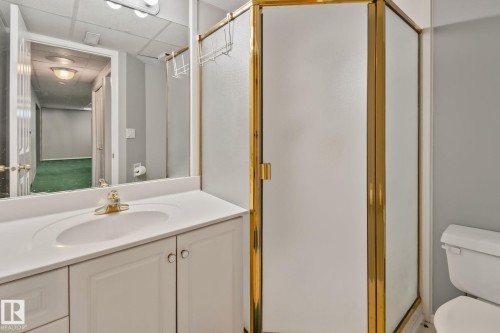 White vanity with integrated sink, brass-finish faucet, and coordinating cabinet hardware - 14724 73 Street Nw, Edmonton, AB 