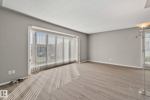 Spacious interior with neutral wall paint and wood-finish flooring - 14724 73 Street Nw, Edmonton, AB 