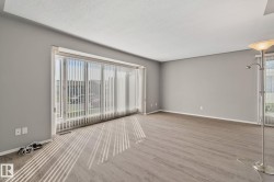 Spacious interior with neutral wall paint and wood-finish flooring - 