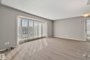 Spacious interior with neutral wall paint and wood-finish flooring - 14724 73 Street Nw, Edmonton, AB 
