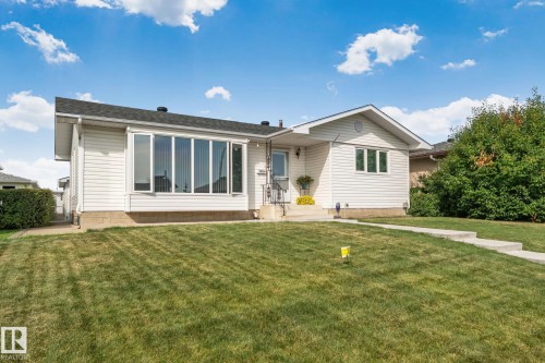Exterior featuring white siding, a prominent bay window, a gabled roofline, and a concrete walkway - 14724 73 Street Nw, Edmonton, AB 