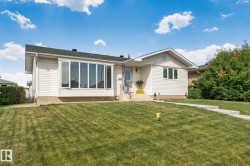 Exterior featuring white siding, a prominent bay window, a gabled roofline, and a concrete walkway - 