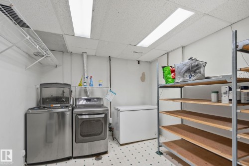 Laundry area with a patterned tile floor, overhead fluorescent lighting, and built-in metal shelving - 14724 73 Street Nw, Edmonton, AB 