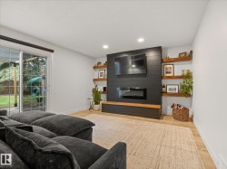 Living area featuring light wood-finish flooring, white walls, and recessed lighting - 