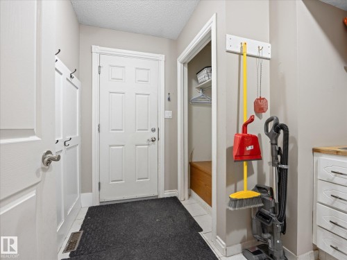 Mudroom entry featuring a six-panel door, built-in coat hooks, and a bench storage nook - 4 Lovatt Place, St. Albert, AB - Indoor Photo Showing Other Room