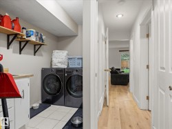 Dedicated laundry area featuring a built-in countertop, shelving, and tile flooring - 