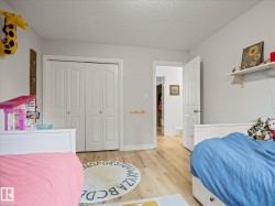 Light-toned wood-finish flooring throughout, featuring painted white walls and white trim - 