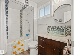 Modern bathroom featuring a deep soaking tub with subway tile surround and decorative mosaic accents - 
