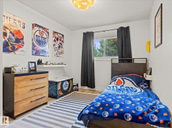 Bright interior space featuring a window with exterior tree views, light wood-finish flooring, and a white floating shelf - 