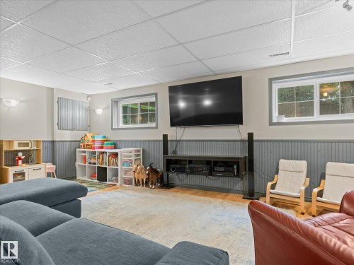 Finished lower level featuring recessed lighting, a drop ceiling, wood-finish flooring, and two windows providing natural light - 4 Lovatt Place, St. Albert, AB - Indoor Photo Showing Other Room