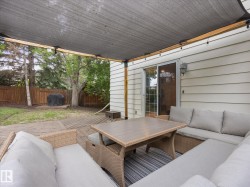 Expansive wood-finish deck with an overhead shade structure, featuring string lighting and direct access to the interior via a sliding glass door - 