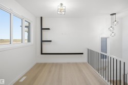 Light wood-finish flooring, built-in shelving, white walls, and contemporary light fixtures - 