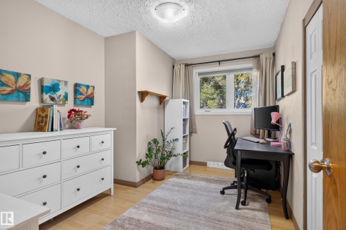 Light wood-finish flooring, neutral wall tones, and a single window with natural light - 14611 109 Avenue Nw, Edmonton, AB 