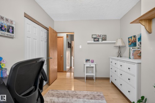 Neutral wall paint, wood-finish flooring, and white paneled closet doors - 14611 109 Avenue Nw, Edmonton, AB 