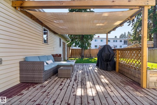 Covered wood deck with sunshade, lattice privacy screen, and light-colored siding - 14611 109 Avenue Nw, Edmonton, AB 