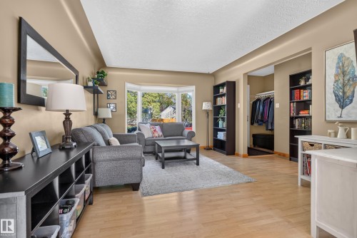 Wood-finish flooring throughout, featuring a bay window, recessed entryway, and built-in shelving - 14611 109 Avenue Nw, Edmonton, AB 