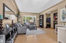 Wood-finish flooring throughout, featuring a bay window, recessed entryway, and built-in shelving - 14611 109 Avenue Nw, Edmonton, AB 