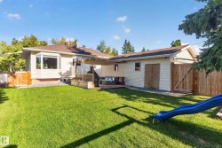 Expansive green lawn with a wood fence perimeter - 