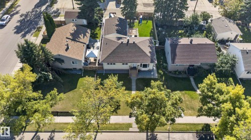 Front-facing property with a sidewalk, mature trees, and a shingled roof - 14611 109 Avenue Nw, Edmonton, AB 