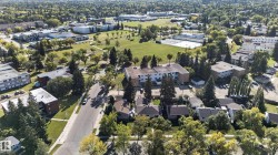 Aerial perspective showcasing residential properties amidst mature trees and green spaces - 
