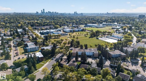 Expansive neighborhood featuring mature trees, paved streets, and a distant city skyline - 14611 109 Avenue Nw, Edmonton, AB 