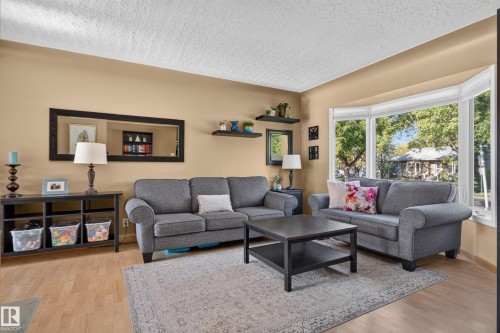 Wood-finish flooring, bay window, light neutral wall color, built-in shelving, and white ceiling - 14611 109 Avenue Nw, Edmonton, AB 