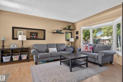 Wood-finish flooring, bay window, light neutral wall color, built-in shelving, and white ceiling - 