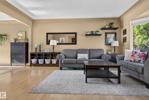 Hardwood flooring throughout, recessed archway, built-in shelving, and large window - 14611 109 Avenue Nw, Edmonton, AB 