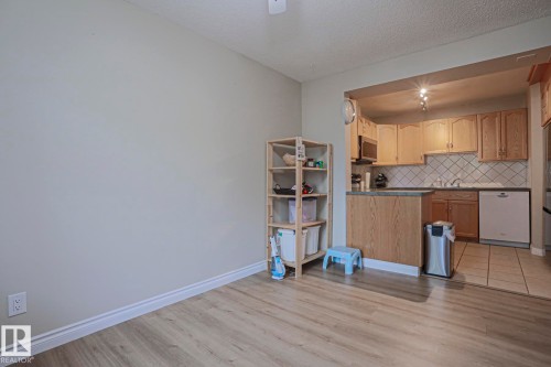 Open kitchen featuring wood cabinetry, integrated microwave, tile backsplash, and a dishwasher - 319 Telford Court, Leduc, AB 