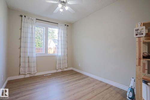 Wood-finish flooring, white trim, and a ceiling fan with integrated lighting - 319 Telford Court, Leduc, AB 