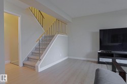 Carpeted staircase with metal balusters and a wood-finish handrail - 