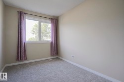 Wall-to-wall carpeting, neutral wall color, and a window with white trim - 