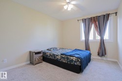Neutral wall color, ceiling-mounted light fixture with fan, large window with white frame, and wall-to-wall carpeting - 