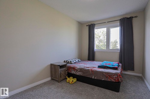 Neutral wall paint, window with trim, and carpeted flooring - 319 Telford Court, Leduc, AB 