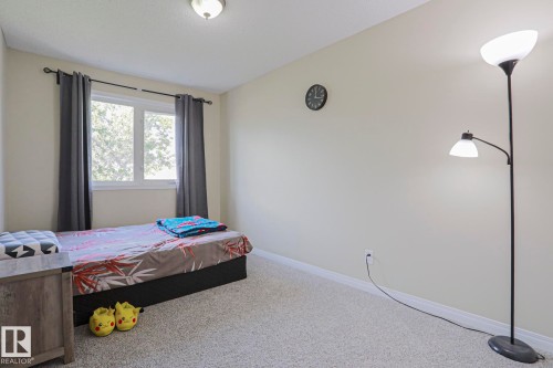 Recessed lighting, large window with curtain rod, and neutral carpet flooring - 319 Telford Court, Leduc, AB 