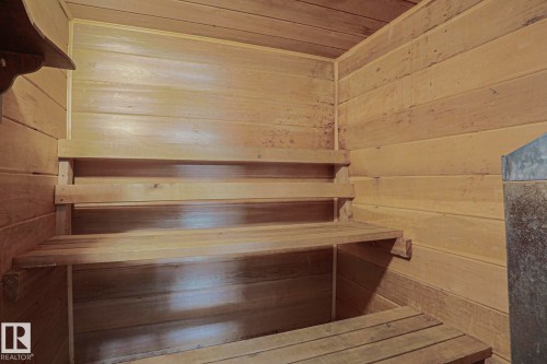 Wood-paneled interior with built-in wooden benches and a permanent metallic fixture - 319 Telford Court, Leduc, AB 