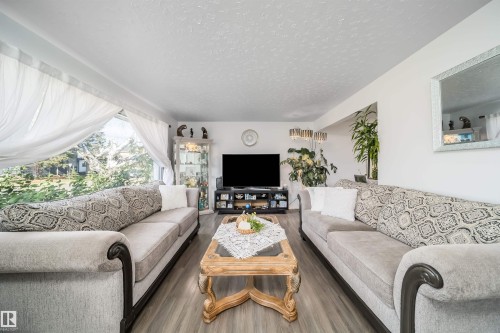Expansive window providing abundant natural light, wood-finish flooring, and white painted walls - 10245 160 Street Nw, Edmonton, AB 