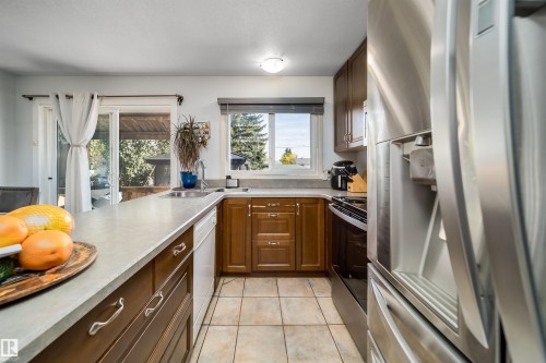 Kitchen featuring wood-finish cabinetry, light-toned countertops, and tile flooring - 10245 160 Street Nw, Edmonton, AB 
