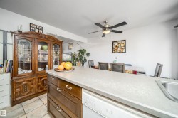 Kitchen island with integrated sink and dishwasher, featuring a light-toned countertop - 
