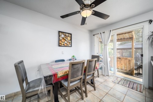 Tiled flooring, ceiling fan with light fixture, white walls, and a sliding glass door leading to an outdoor space - 10245 160 Street Nw, Edmonton, AB 