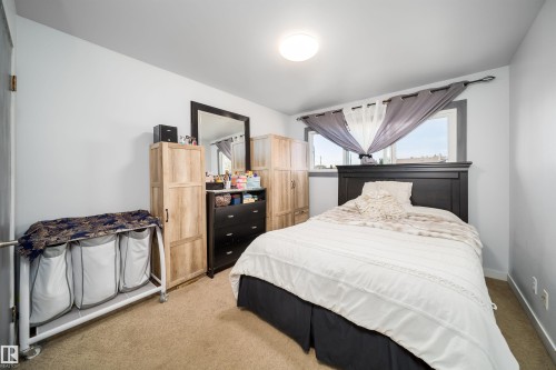 Carpeted flooring, a window with dark trim, and a flush-mount ceiling light fixture - 10245 160 Street Nw, Edmonton, AB 